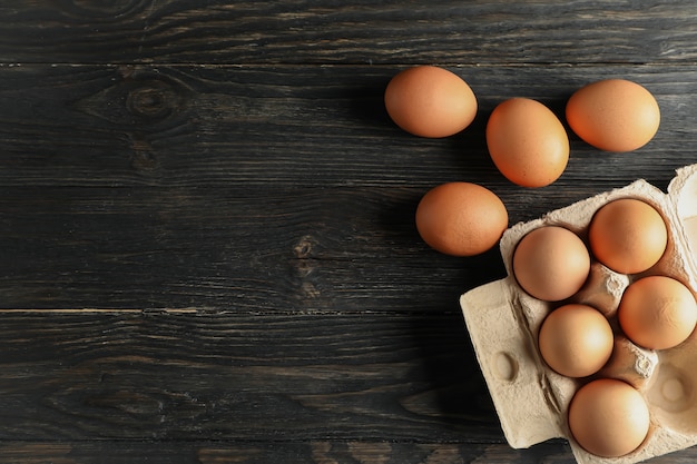 Huevos de gallina en caja de cartón en madera