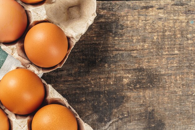 Huevos de gallina en caja sobre fondo de madera