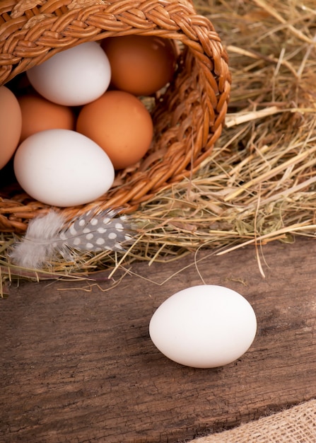 Huevos de gallina en canasta sobre fondo de madera