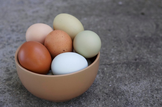 huevos de gallina coloridos de granja en tazón de cerámica