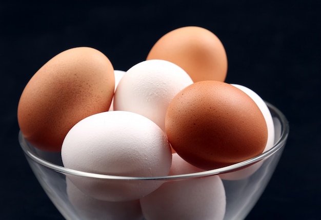 Los huevos de gallina se encuentran en la placa en la oscuridad