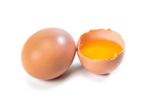Huevos de gallina enteros y agrietados sobre fondo blanco Huevos orgánicos de primer plano