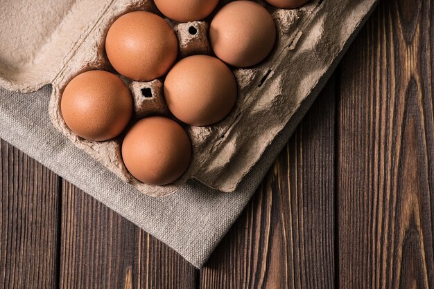 Huevos de gallina en el fondo de la mesa de madera