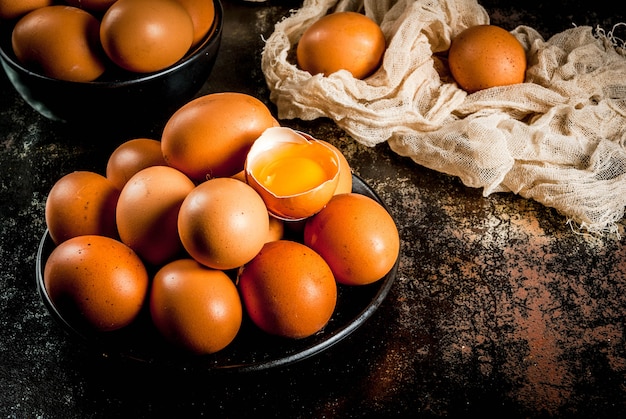 Huevos de gallina de granja orgánica, en un plato, sobre un metal oxidado oscuro, copyspace