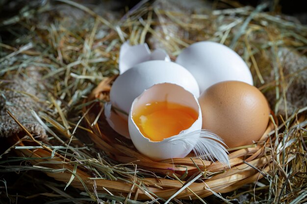 Huevos de gallina en hierba seca en un fondo viejo