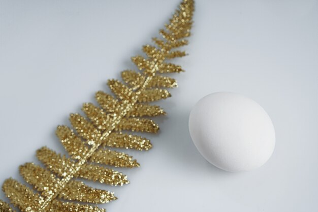 Los huevos de gallina naturales son un símbolo de la Pascua. Hojas de palma dorada.