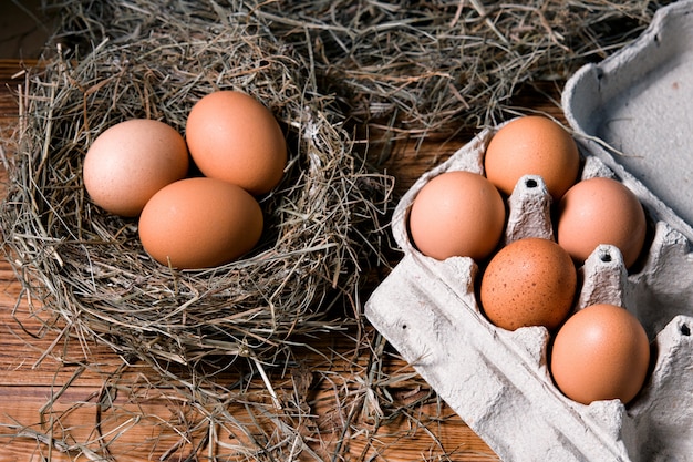 Huevos de gallina en nidos de mimbre en gallinero vista superior. Huevos orgánicos naturales en el heno. Huevos de gallina frescos.