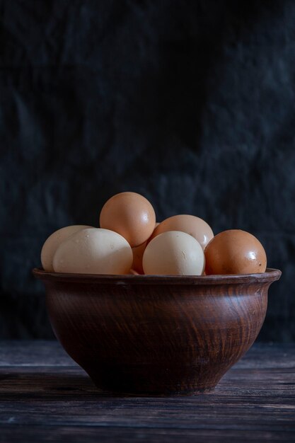 Huevos de gallina en un plato de arcilla sobre la mesa