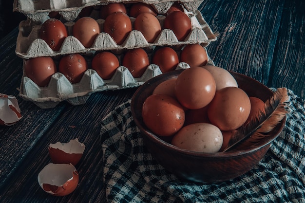 Huevos de gallina en un plato de barro y bandejas sobre la mesa