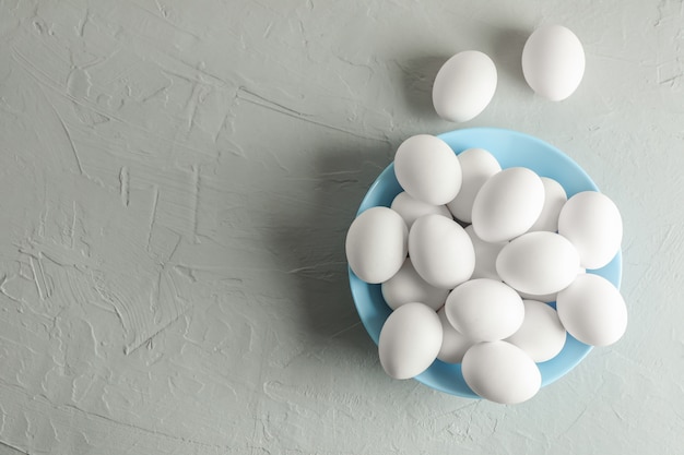 Huevos de gallina en plato en gris