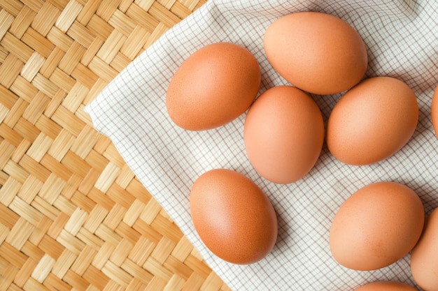 Los huevos de gallina ponen sobre una tela escocesa blanca Concepto de alimentos para bajar de peso