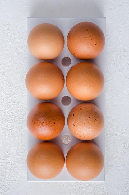 Huevos de gallina roja en la bandeja de la nevera.