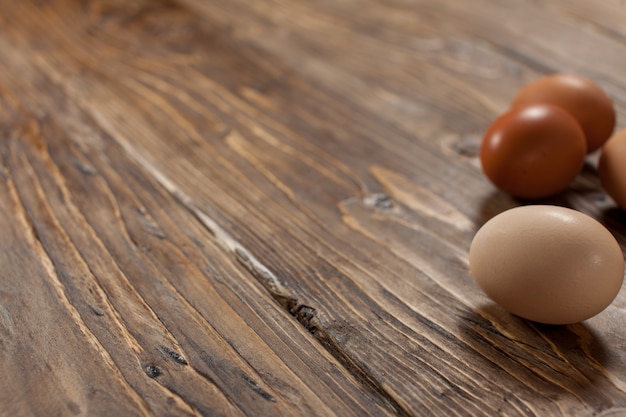 Foto huevos de gallina sobre base rústica con textura de madera