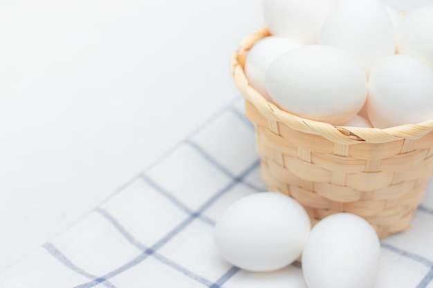 Huevos de gallina sobre una toalla de cocina marcada sobre una mesa de luz