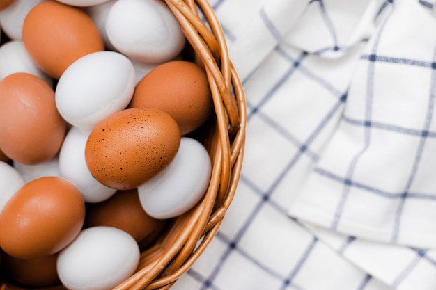 Huevos de gallina en una toalla de cocina marcada en una mesa de luz. concepto de productos agrícolas y alimentos naturales. productos para el hogar Huevos de gallina frescos.