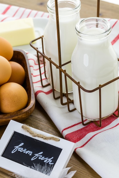 Huevos de granja frescos, leche y mantequilla en la mesa de madera.