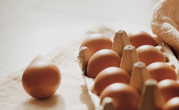Huevos de granja orgánica en caja de huevos y servilletas de tela rústica, primer plano