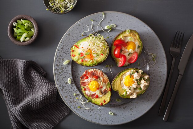 Huevos horneados en aguacate con tocino, tomate, tomate y brotes de alfalfa