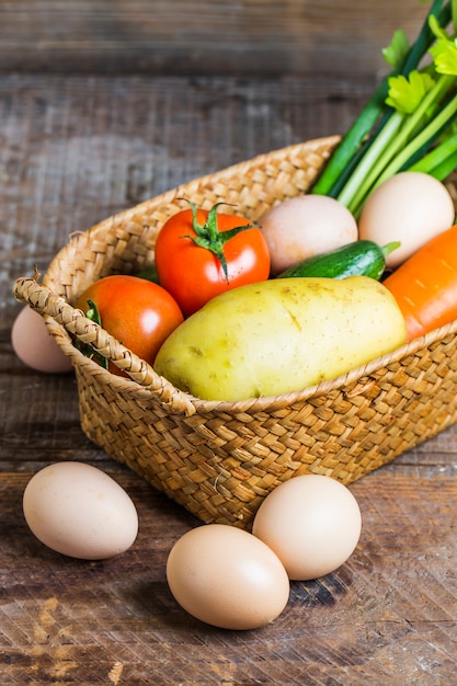 Huevos junto a una cesta con verduras