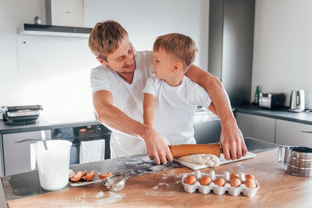 Huevos, leche y masa padre enseñando a su pequeño hijo a preparar dulces  galletas navideñas | Foto Premium