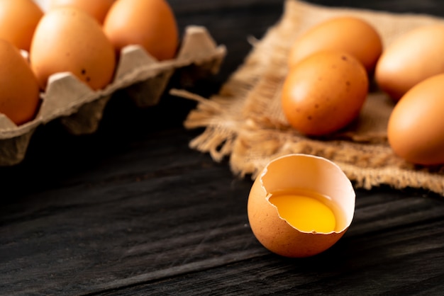 Huevos marrones con una yema rota y yema de huevo