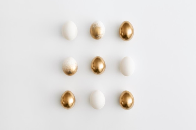 Huevos de oro sobre un fondo blanco Concepto mínimo de pascua
