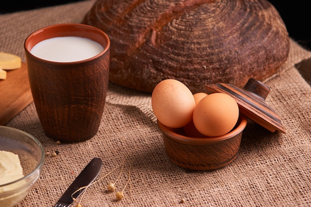 Huevos con pan y utensilios de cocina sobre fondo de madera vintage. Comida sabrosa