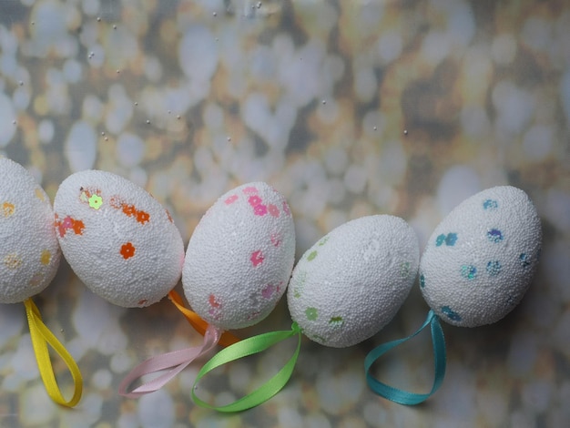 Huevos de Pascua alineados en una mesa con gotas de agua sobre ellos.