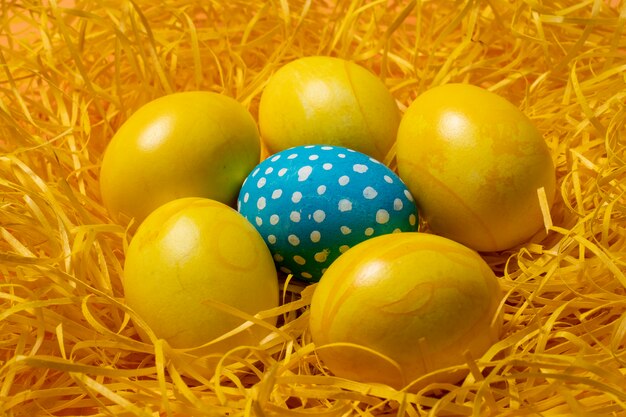 Huevos de Pascua amarillos sobre fondo de paja