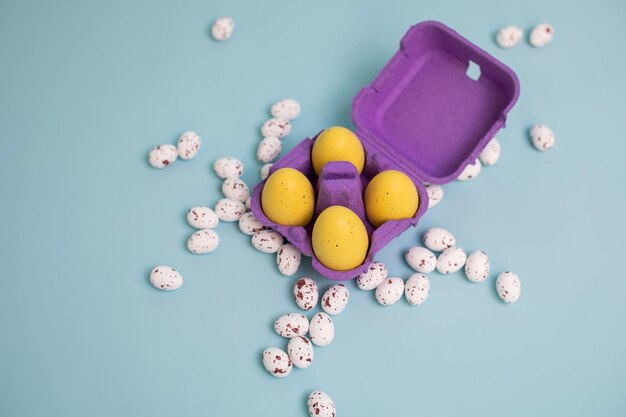 Huevos de Pascua en bandeja de cartón aislados en una vista superior de fondo azul