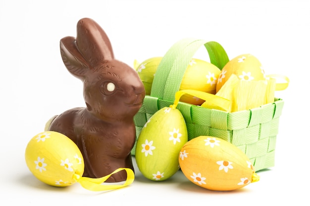 Huevos de Pascua en una canasta con conejito de chocolate