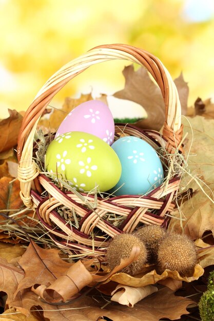 Huevos de Pascua en canasta de mimbre escondidos en hojas