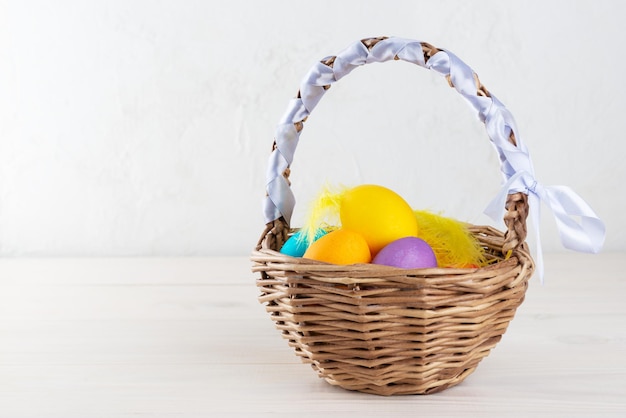 Huevos de Pascua en una canasta sobre una mesa de madera Espacio de copia de orientación horizontal