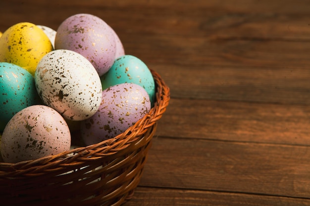 Huevos de Pascua en una canasta sobre una mesa de madera