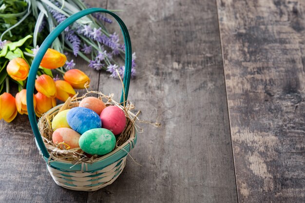 Huevos de Pascua en una canasta y tulipanes