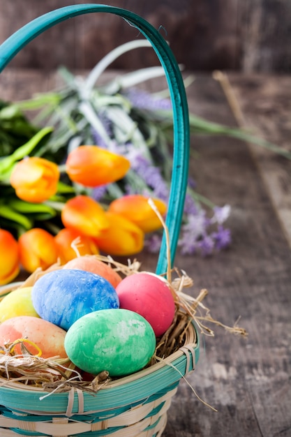 Huevos de Pascua en una canasta y tulipanes