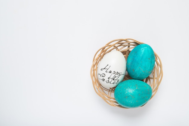 Huevos de Pascua en una cesta en un blanco