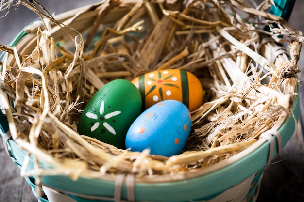 Huevos de Pascua en una cesta en la mesa de madera