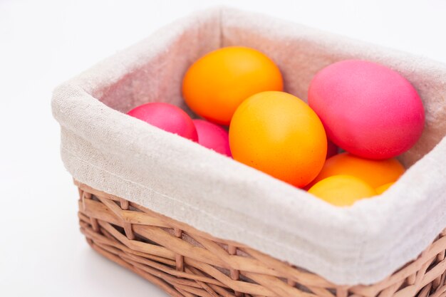 Huevos de Pascua en una cesta de mimbre. Felices Pascuas. huevos pintados sobre una superficie clara