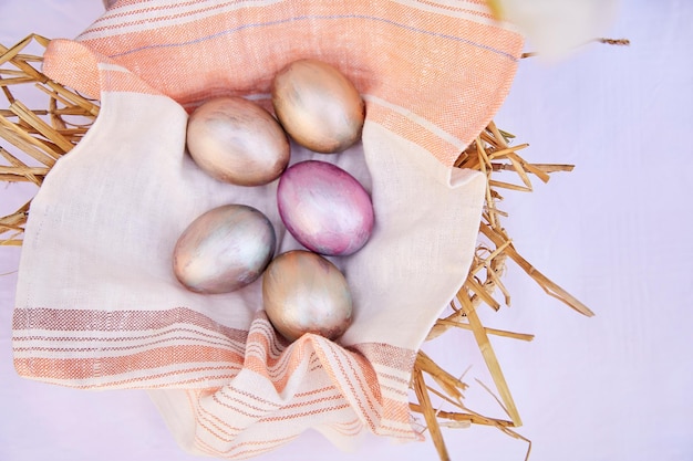 Huevos de Pascua en cesta de paja de mimbre Veri peri y naranja huevos multicolores Vista desde arriba