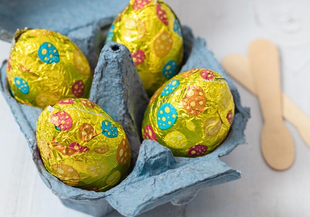 Huevos de Pascua de chocolate en una caja de huevos de cartón sobre una mesa blanca