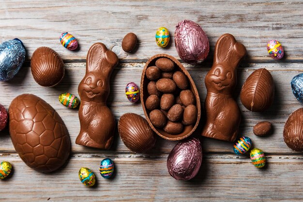 Huevos de pascua de chocolate y conejitos sobre un fondo de madera rústica