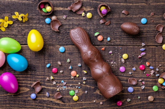 Foto huevos de pascua de chocolate y dulces en la mesa de madera