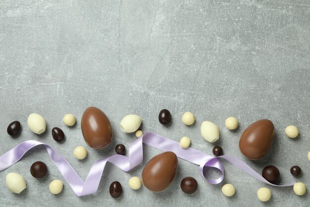 Huevos de Pascua de chocolate y dulces en superficie gris