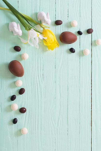 Huevos de Pascua de chocolate y flores sobre la superficie de madera verde