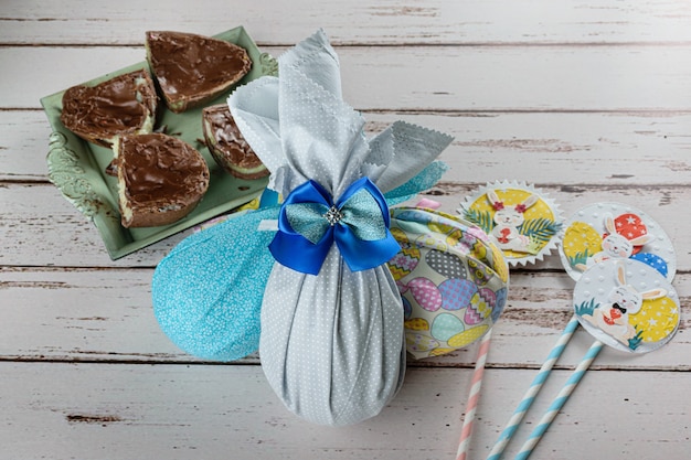 Huevos de Pascua de chocolate llenos de telas de colores. Junto al huevo de Pascua relleno de brigadeiro blanco (brigadier).