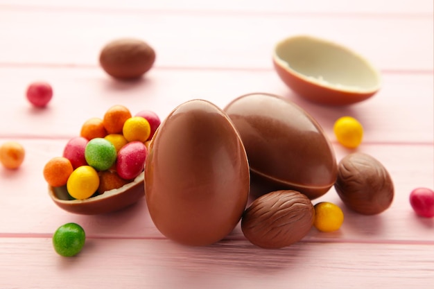 Huevos de pascua de chocolate sobre fondo rosa de madera