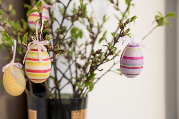 Foto huevos de pascua colgando de una rama de flor de primavera