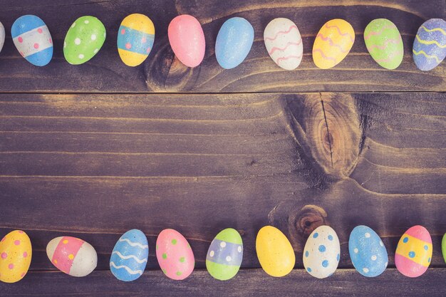 Huevos de Pascua de Coloeful en fondo de madera del tablón con el espacio.