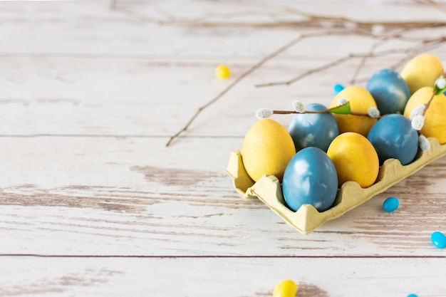Huevos de pascua de color azul y amarillo de mármol en la mesa de madera